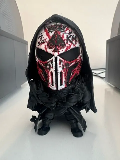 Small hooded figure wearing a miniature Ace of Bladez mask