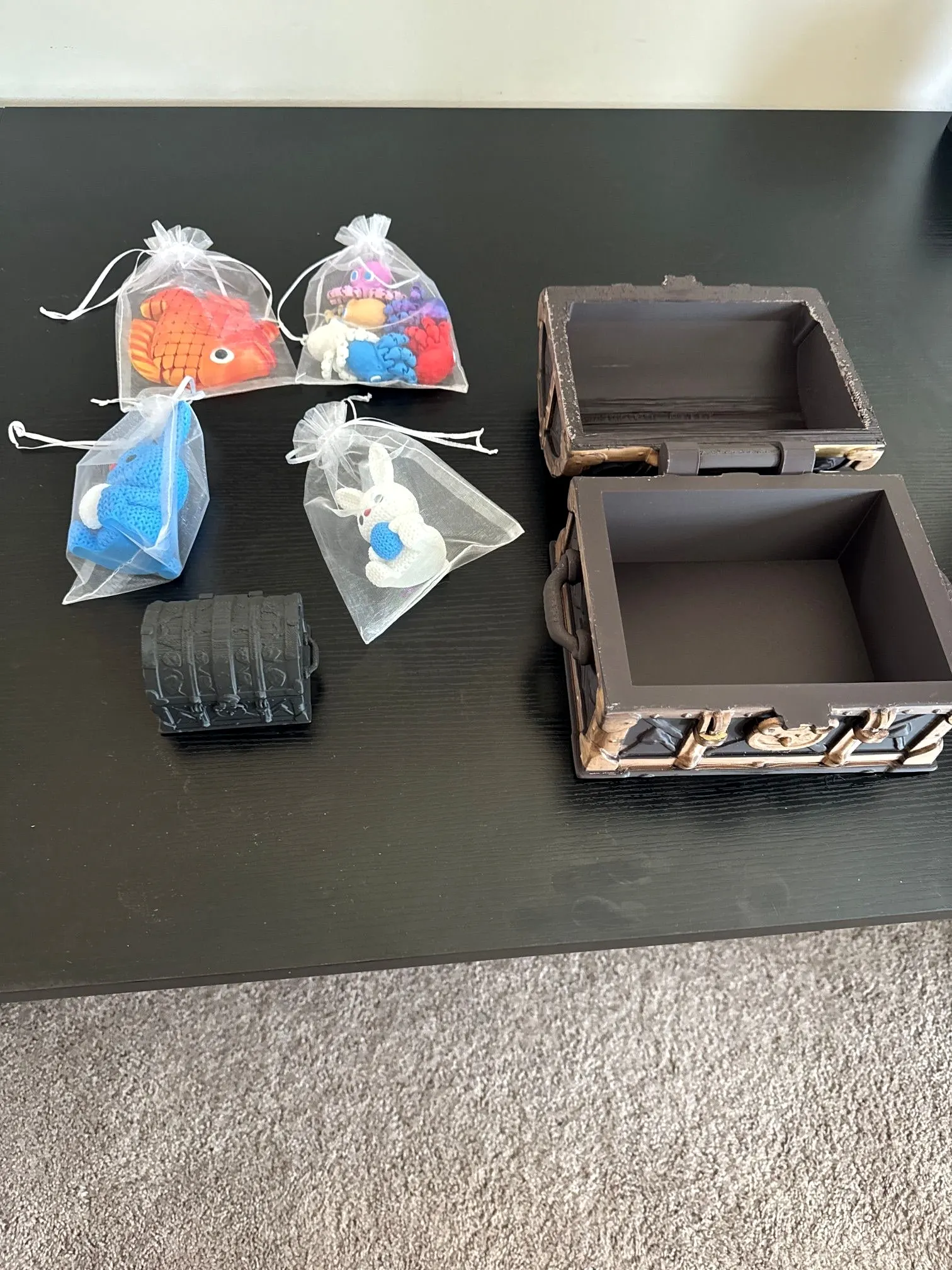 Open treasure chest beside bags of small articulated animal toys